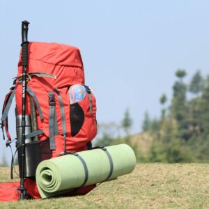 Selective Focus Photo of Red Hiking Backpack on Green Grass