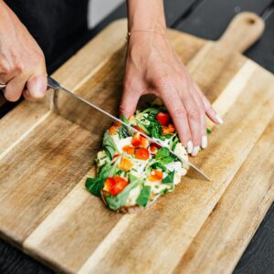 Close-up of Woman Cutting Food on Board