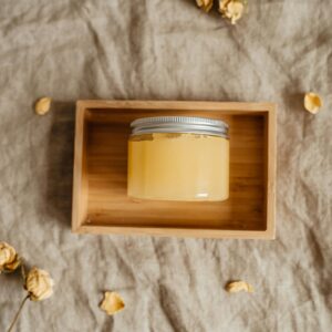 Glass Jar of Yellow Cosmetic Balm in a Wooden Box